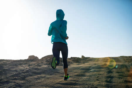 Fitness woman trail runner cross country running  on sand desertの写真素材