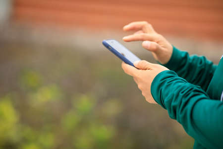 Asian woman using smartphone outdoorsの写真素材