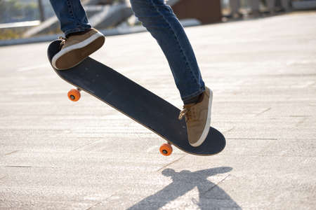 Asian woman skateboarder skateboarding in modern cityの写真素材