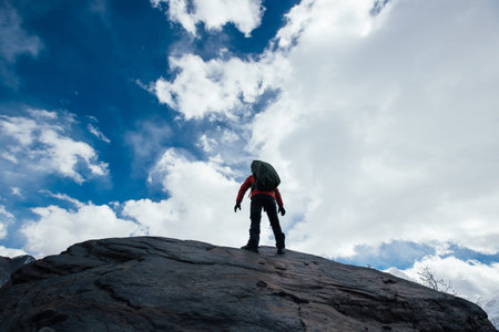 Woman hiker enjoy the view on winter mountain top cliff edge