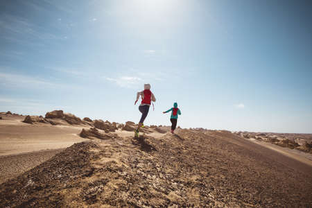 Two women trail runners cross country running in the desertの写真素材