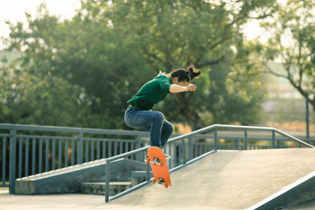 Asian woman skateboarder skateboarding at skatepark