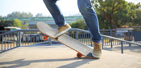 Asian woman skateboarder skateboarding at skateparkの写真素材