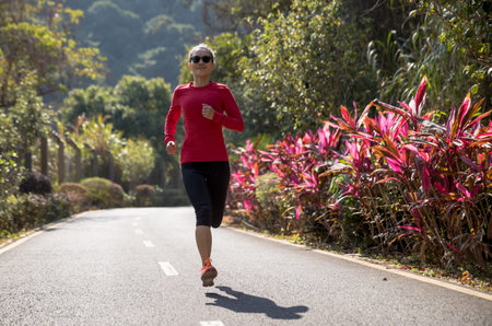 Fitness woman runner running on winter park trail