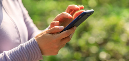 Asian woman using smartphone outdoors