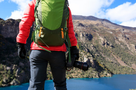 Woman photographer with camera in beautiful high altitude winter mountainsの写真素材