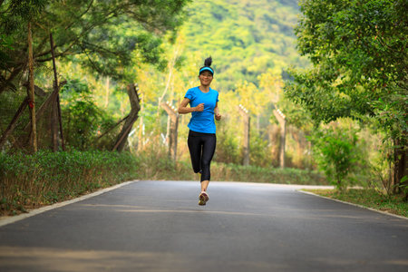Fitness woman running on forest trail