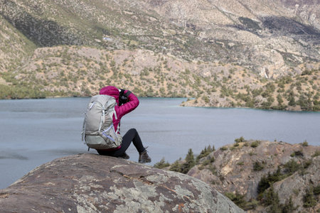 Woman backpacker taking photo in beautiful winter mountains