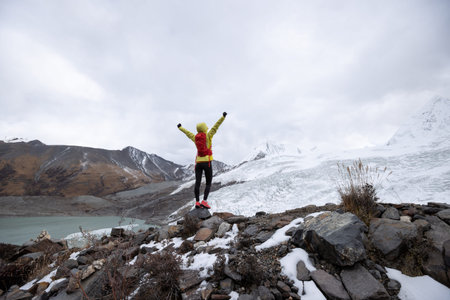 Successful woman trail runner open arms to winter fossil glacier snow mountainsの写真素材
