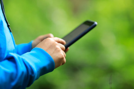 Woman hiker using smartphone  in spring forestの写真素材