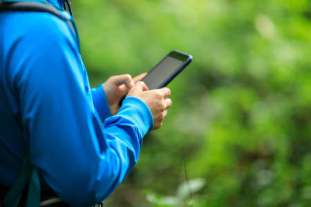 Woman hiker using smartphone  in spring forestの写真素材