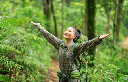 Freedom woman backpacker  hiking open arms in spring forestの写真素材