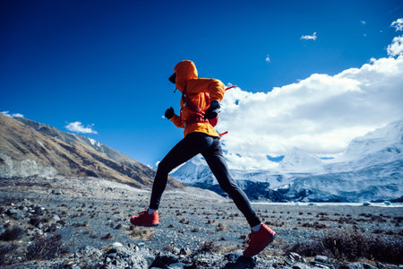 Woman trail runner cross country running in high altitude winter nature