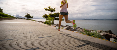 Fitness woman running training for marathon on sunny coast trailの写真素材