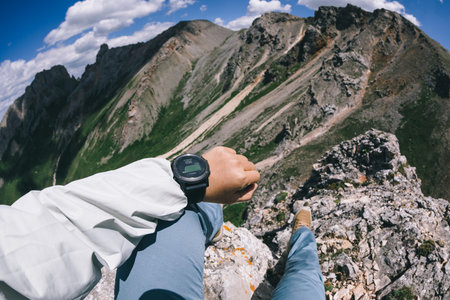 Hiker on high altitude mountain top checking the altimeter on the sports watch