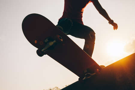 Asian woman skateboarder skateboarding at skateparkの写真素材
