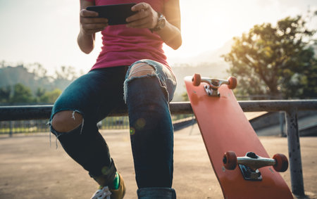 Skateboarder use mobile phone at skatepark
