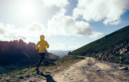 Woman ultramarathon runner running at mountain topの写真素材
