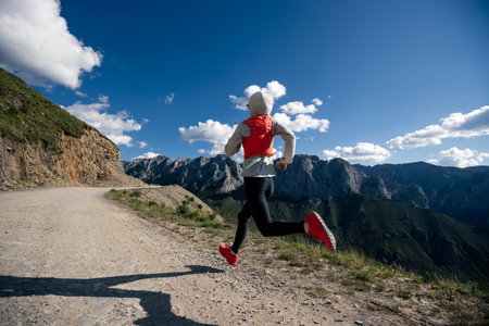 Woman trail runner running on mountain topの写真素材