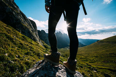 Successful woman backpacker hiking on sunset alpine mountain peakの写真素材