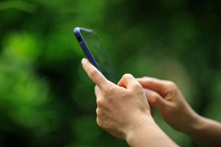 Hands using mobile phone taking picture in summer natureの写真素材
