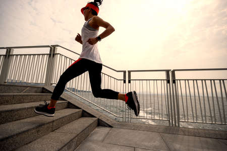 Healthy lifestyle fitness sports woman runner running on seaside trailの写真素材