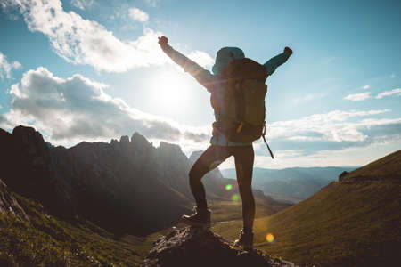 Successful woman backpacker hiking on alpine mountain peakの写真素材