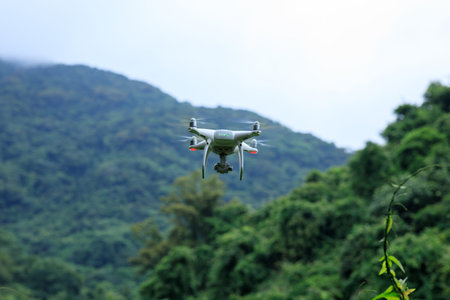White drone with camera flying in summer mountainsの写真素材