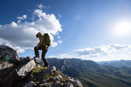 Woman hiker with camera on high altitude mountain topの写真素材