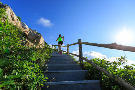 Young fitness woman running upstairs on mountain stairs