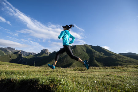 Young woman runner running at mountain topの写真素材