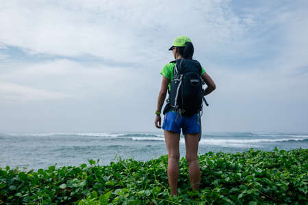 Woman enjoying nature with her opened arms on seaside cliff edgeの写真素材
