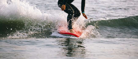 Surfer woman practice surfing in the white waterの写真素材