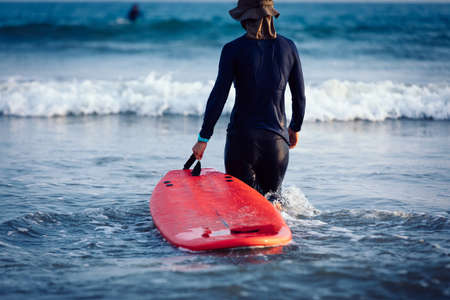 Surfer woman practice surfing in the white waterの写真素材