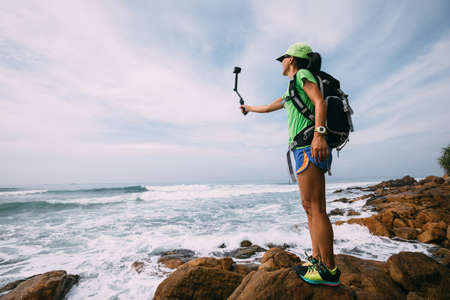 Woman Hiking In Seaside Taking A Selfie With Action Cameraの写真素材