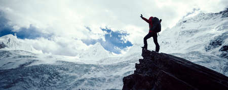 Woman hiker enjoy the view on winter mountain top cliff edgeの写真素材