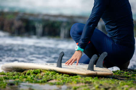 Woman surfer with surfboard on seasideの写真素材