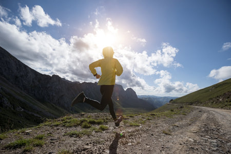 Young woman ultramarathon runner running at mountain topの写真素材