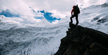 Successful woman hiker hiking in winter mountainsの写真素材