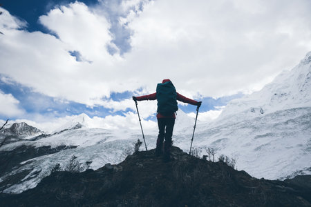 Successful woman backpacker hiking in winter mountainsの写真素材