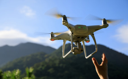 Hand reaching for a flying drone in summer forest