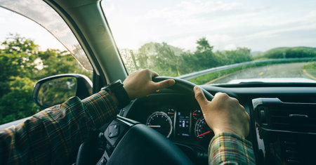 People driving car on sunrise mountain roadの写真素材