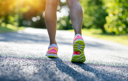 Fitness woman runner ready for running on sunny tropical parkの写真素材