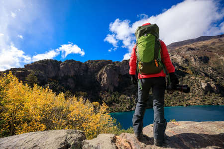 Woman photographer with camera in beautiful high altitude winter mountainsの写真素材