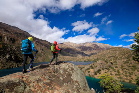 Two women backpackers hiking  in beautiful winter mountainsの写真素材