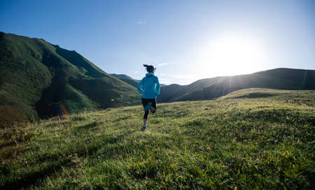 Young woman runner running at mountain topの写真素材
