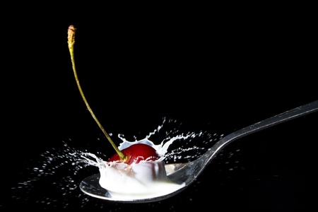 Cherry milk splash iolated on blackの写真素材