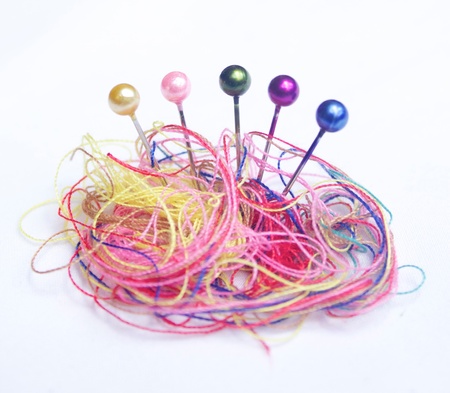 Colourful pins and different coloured threadの写真素材