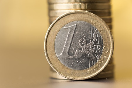 Stack of coins with a smoothly blurred yellow gold background