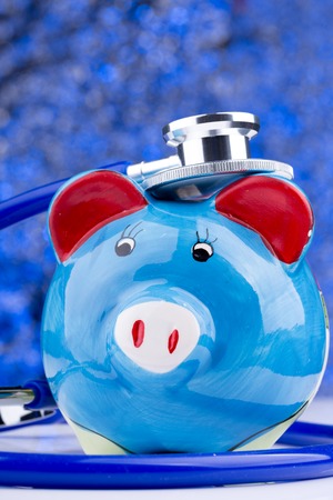 Close up of a stethoscope with a piggy bankの写真素材